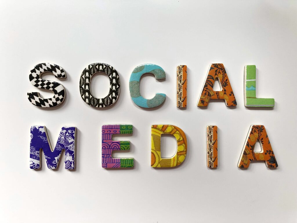 Social media concept image with colorful wooden letters spelling “SOCIAL MEDIA” on a white background.