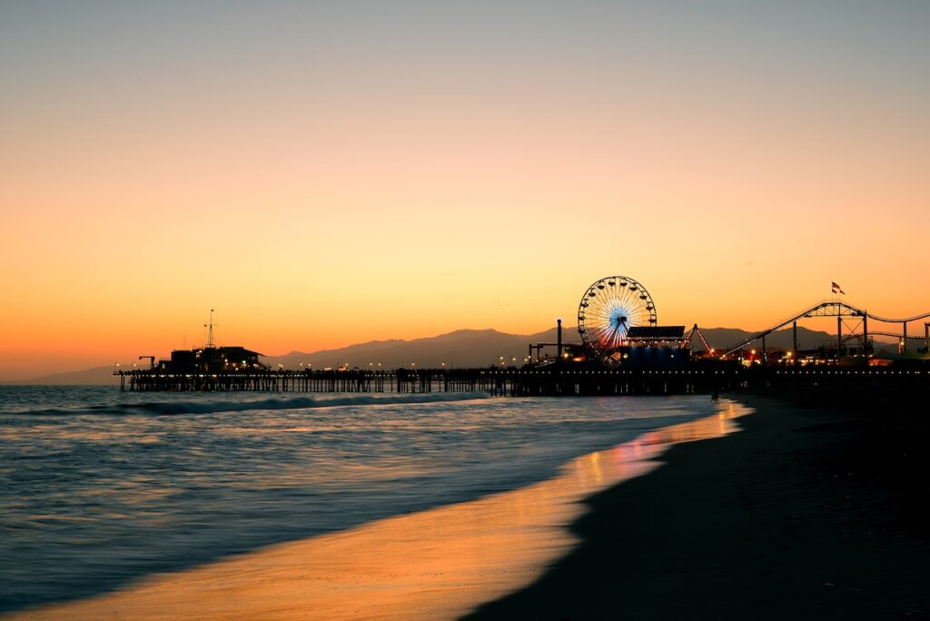 Santa Monica Pier at sunset with beach and ocean in Los Angeles, California
